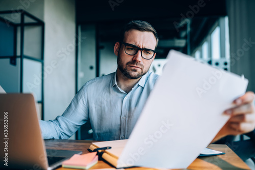 Businessman checking data in documents in office