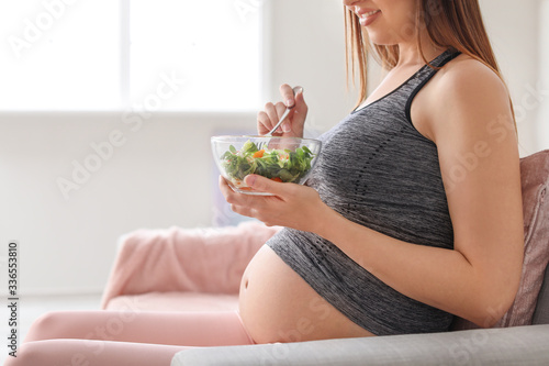 Beautiful pregnant woman ea...