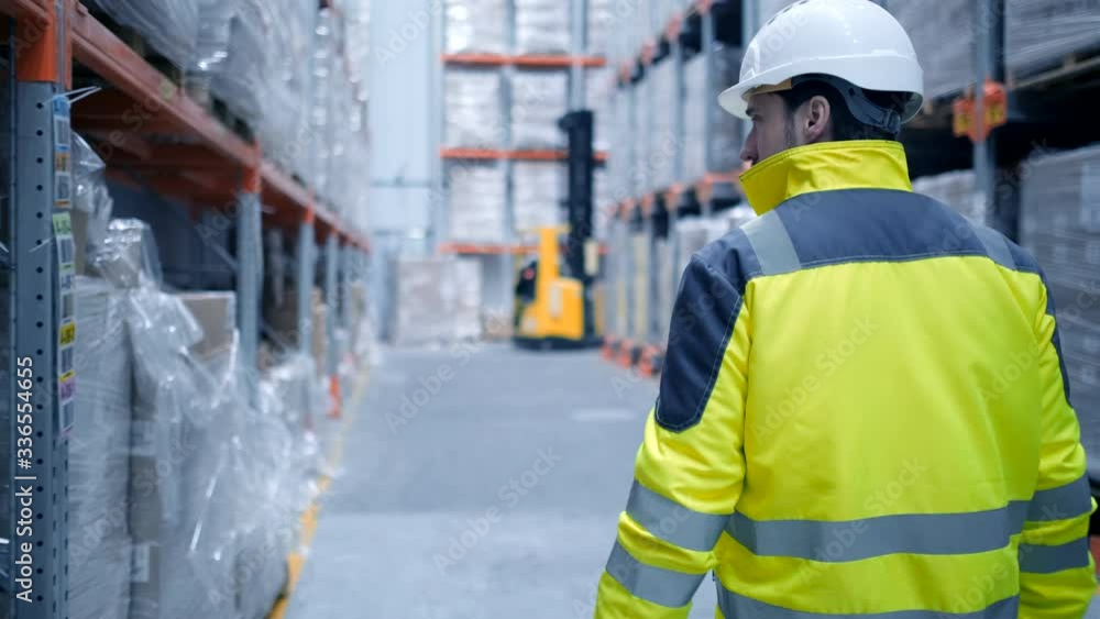Worker male warehouse worker engineer man in a helmet working on the construction site of the warehouse, tablet computer, checking the warehouse, inspection of goods Worker male warehouse worker engineer man in a helmet working on the construction site of the warehouse, tablet computer, checking the warehouse, inspection of goods