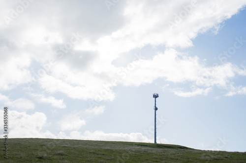 Lanscape of mobile phone tower on farm land with sky and clouds in back ground