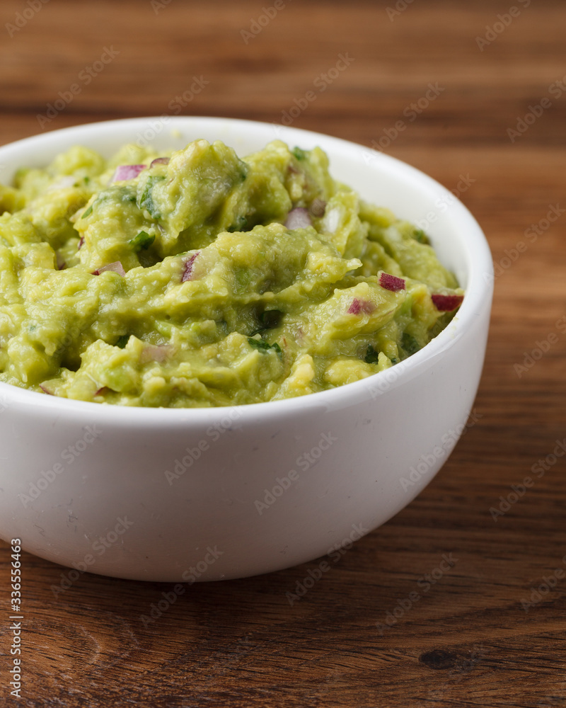 Tigela com Guacamole sobre mesa de madeira Tigela com Guacamole sobre mesa de madeira