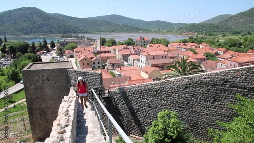 Young woman walking on the defensive wall of Ston town, Peljesac Peninsula, Croatia
