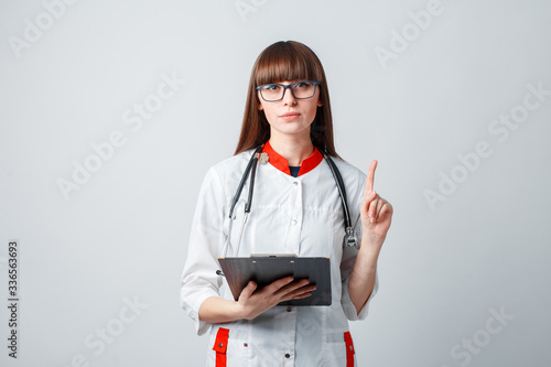 Smiling happy doctor pointing on blue background photo