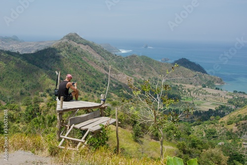 Man resting on hill, countryside view, Lombok