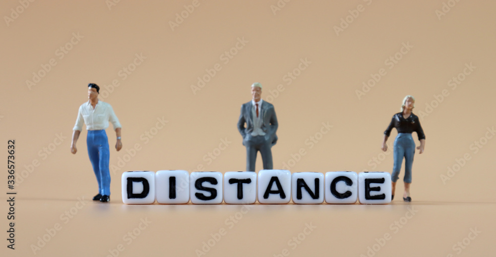 Fototapeta premium Cube with 'DISTANCE' text and miniature people. 