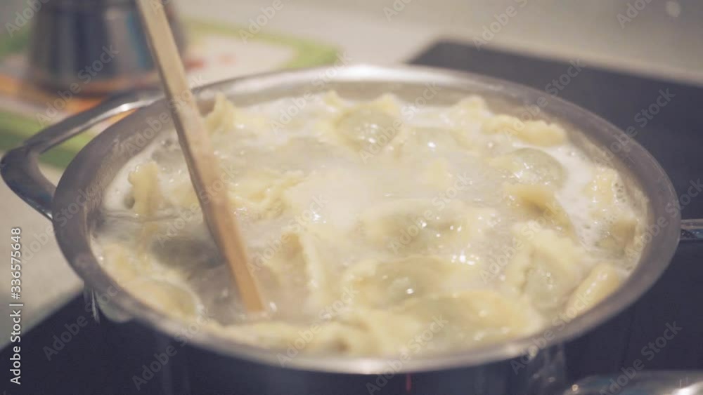 wooden spoon mixes homemade ravioli in boiling pot, slow motion wooden spoon mixes homemade ravioli in boiling pot, slow motion