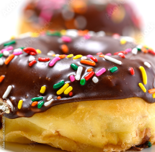 Chocolate glazed donuts with sprinkles on a white background