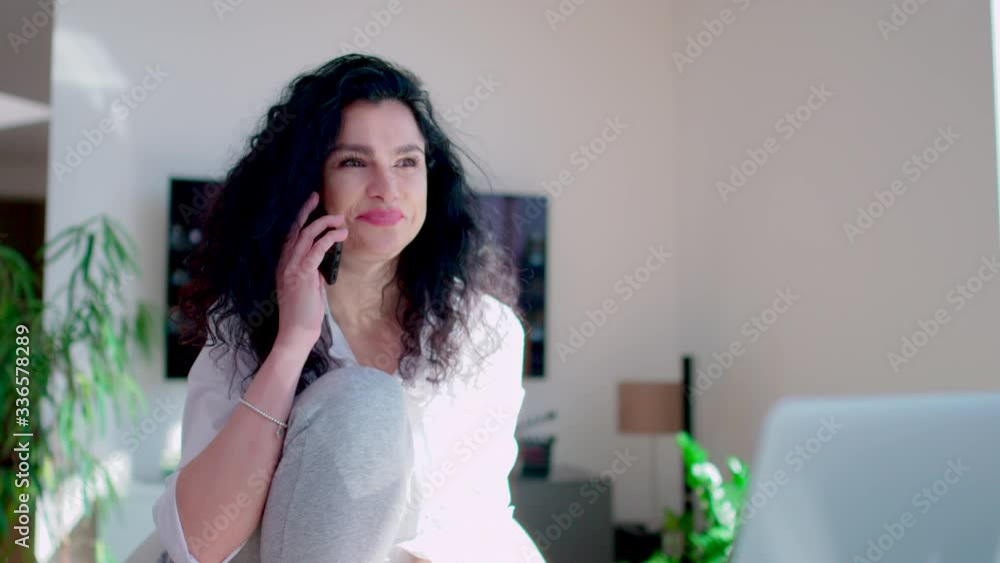Beautiful multi ethnic young business woman on the phone in home office wear cozy jogging pants shot in 4k Beautiful multi ethnic young business woman on the phone in home office wear cozy jogging pants shot in 4k