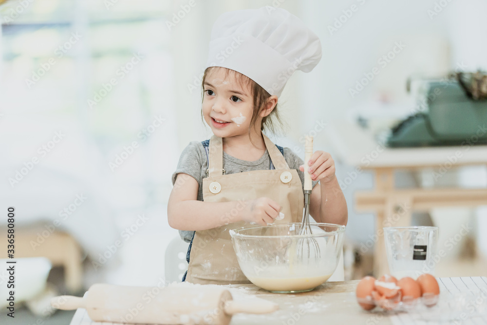 Sweet little cute girl is learning how to make a cake, in the home kitchen, Family concept, Vintage color tone. Sweet little cute girl is learning how to make a cake, in the home kitchen, Family concept, Vintage color tone.