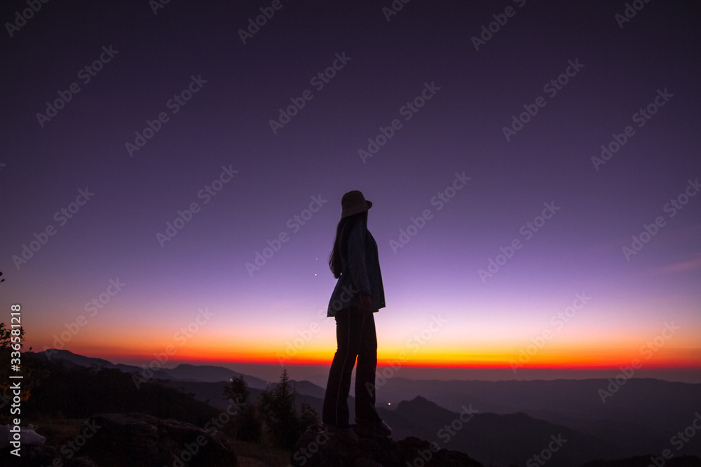 silhouette of woman standing on top of mountain