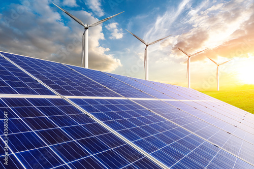 Solar panels with wind turbines in the setting sun,green energy.