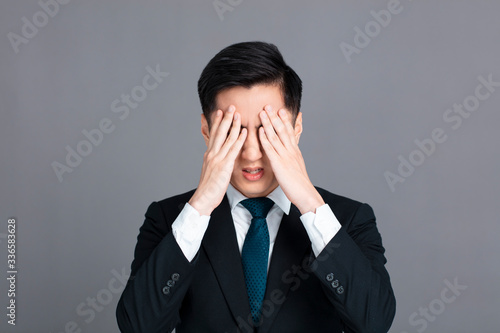 Stressed young business man hand cover eye