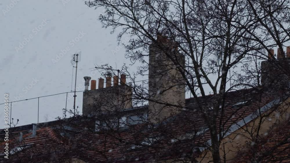 snow falling in slow motion over european old style houses with chimneys snow falling in slow motion over european old style houses with chimneys