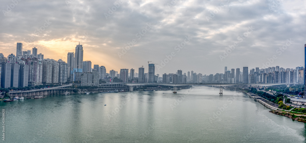 Fototapeta premium Chongqing, China - Dec 22, 2019: Pano view of Sunset over Jialing river with dense residence buiding