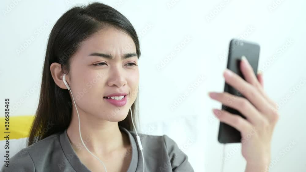 Beautiful young asian woman in grey T-shirt are video calling by mobile phone with her friend, family or boyfriend for social distancing policy. Self quarantine, coronavirus, work from home concept Beautiful young asian woman in grey T-shirt are video calling by mobile phone with her friend, family or boyfriend for social distancing policy. Self quarantine, coronavirus, work from home concept