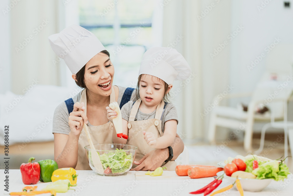 Happy family mom teaching cute girl preparing and cooking healthy salad for the first time. first lesson and healthy lifestyle concept. Happy family mom teaching cute girl preparing and cooking healthy salad for the first time. first lesson and healthy lifestyle concept.