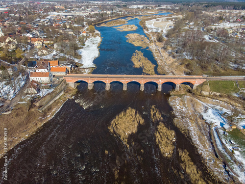 Areal drove photography view of old classic countryside city Kuldiga brick bridge in Europe. photo