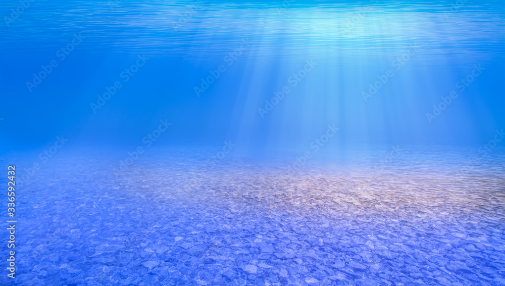 Obraz premium Blue sea or ocean water surface and underwater with sunny day on the foreground pebbles