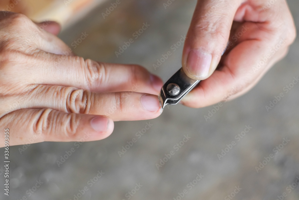 Woman using finger nail clippers close-up.
