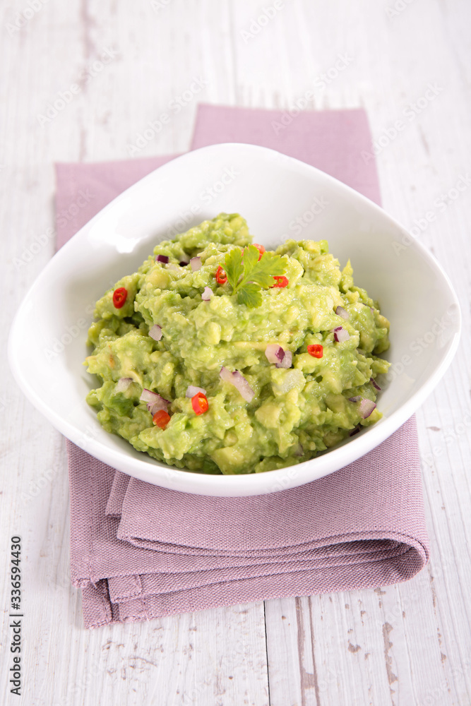 bowl of guacamole with tomato and onion