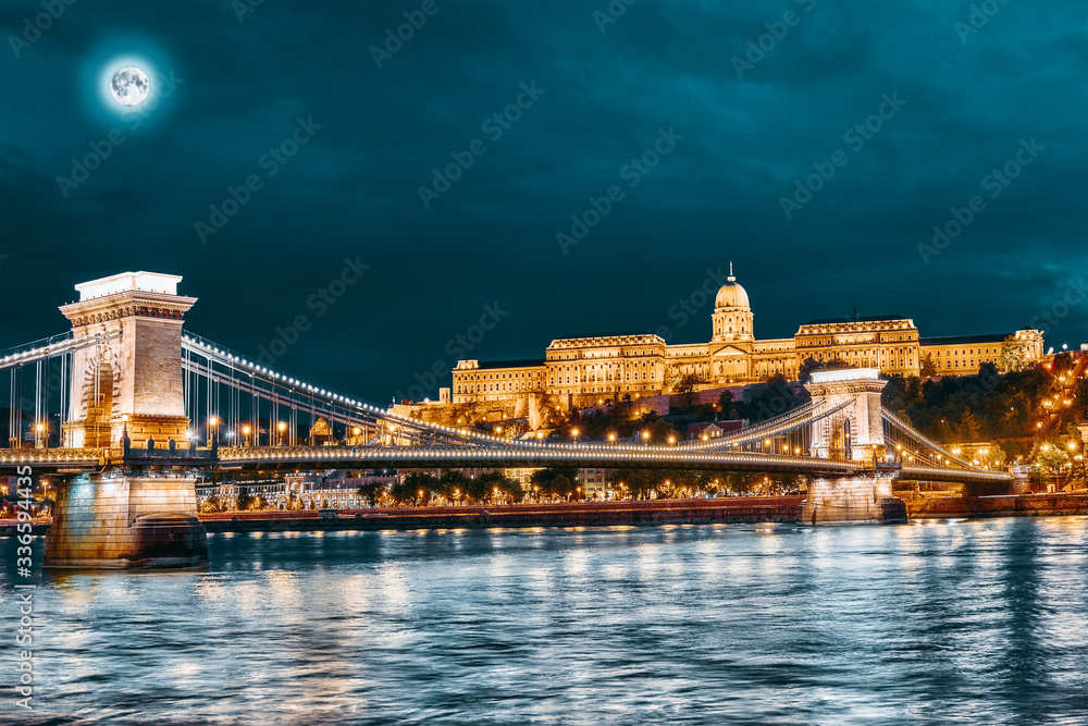 Budapest Royal Castle and Szechenyi Chain Bridge at dusk time from Danube river, Hungary.