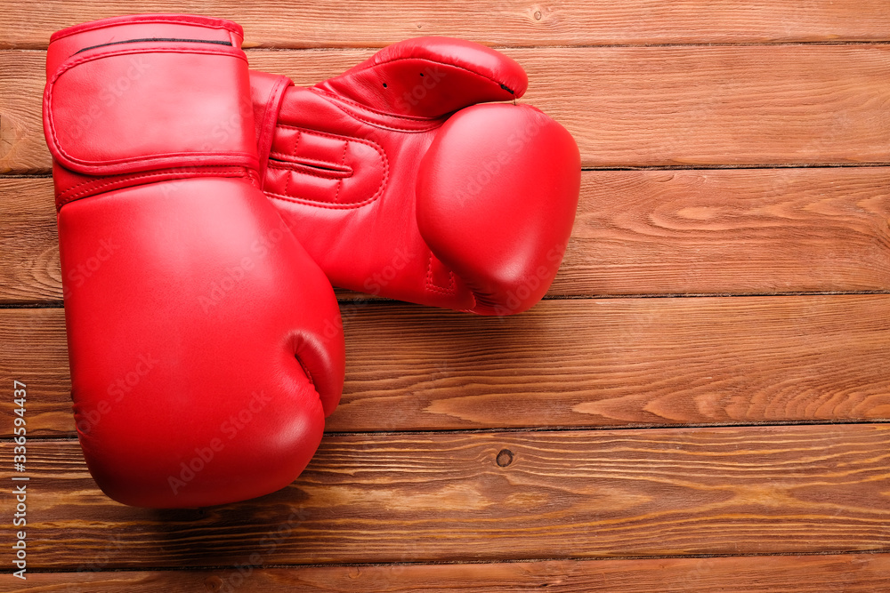 red boxing gloves on wooden boards