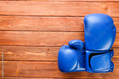 blue boxing gloves on wooden boards