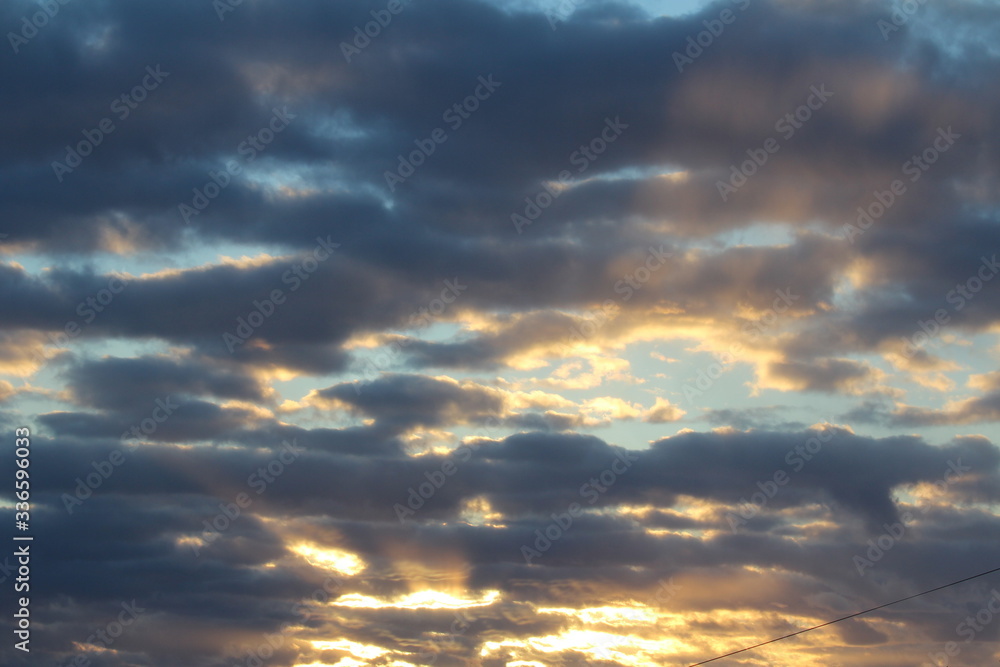 The suns rays pass through the dark clouds. Beautiful dramatic sky at sunset or sunrise.