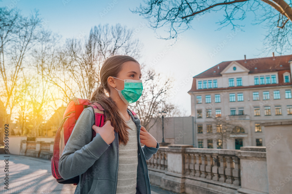 Fototapeta premium Kind mit Maske geht zu Schule