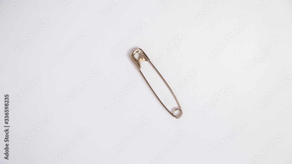 One safety pin isolated on white background, close up One safety pin isolated on white background, close up