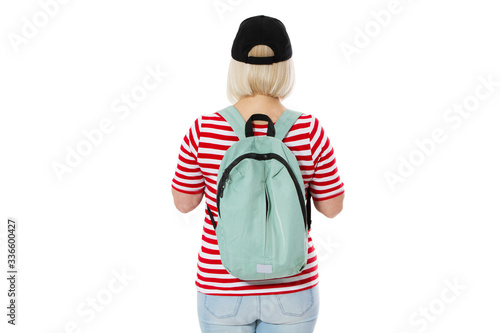Back view of a middle aged woman with a backpack and a black cap