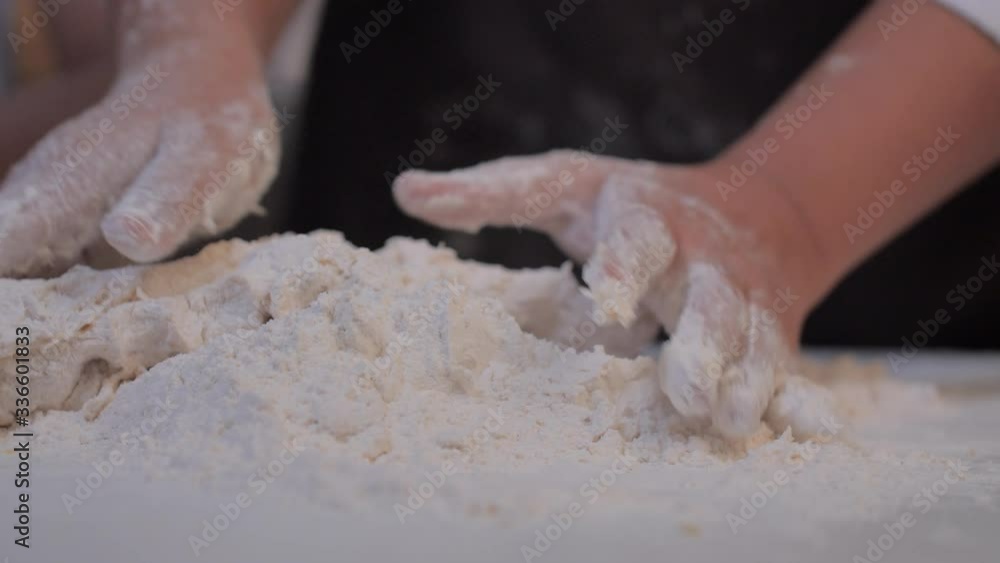 Close-up the hands are kneading the dough for making the bakery on the white table. Close-up the hands are kneading the dough for making the bakery on the white table.