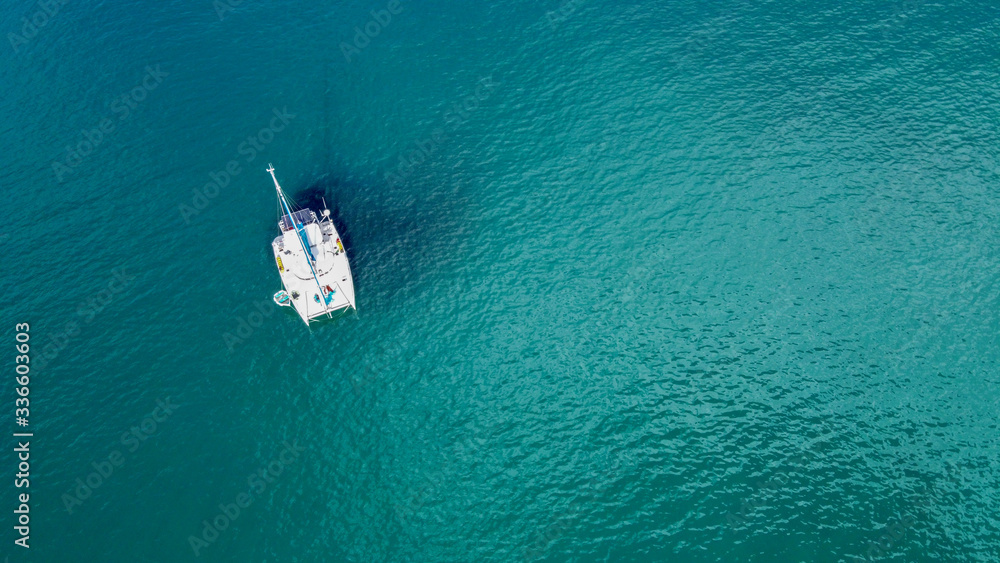 The drone captures a high angle view of catamaran sailboats moored in the Andaman sea.