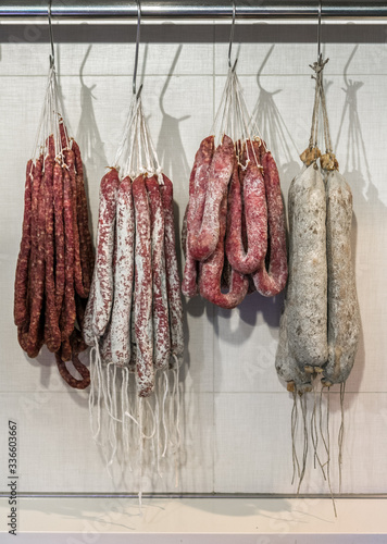 Varios embutidos de cerdo colgados con un cordel en un gancho.