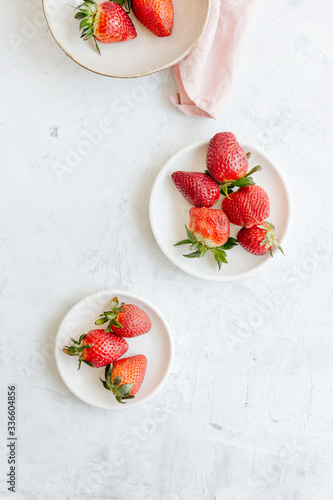 Plates with strawberries on a white background, top view, flat