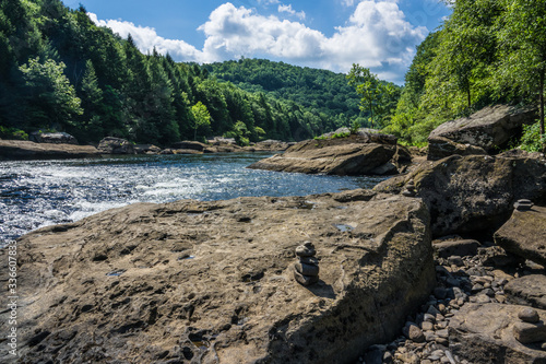 This image of the Gauley River in West Virginia, was captured while standing on a large boulder on the shoreline. A cairn is seen in the foreground.