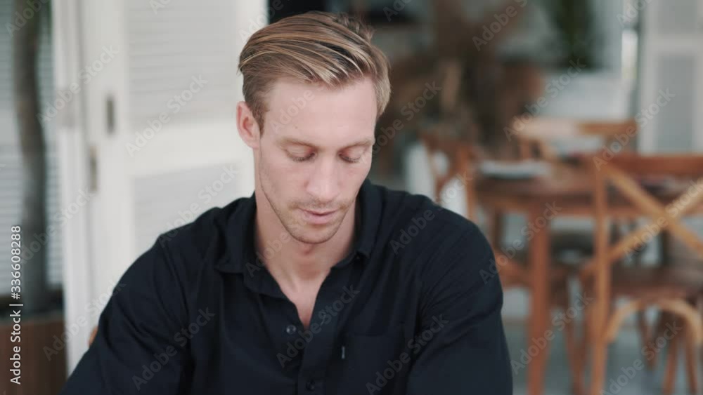 Portrait of handsome man drinking coffee in cafe, looks at camera and smiling Portrait of handsome man drinking coffee in cafe, looks at camera and smiling