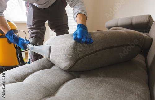 Fotografija Man cleaning sofa chemical cleaning with professionally extraction method