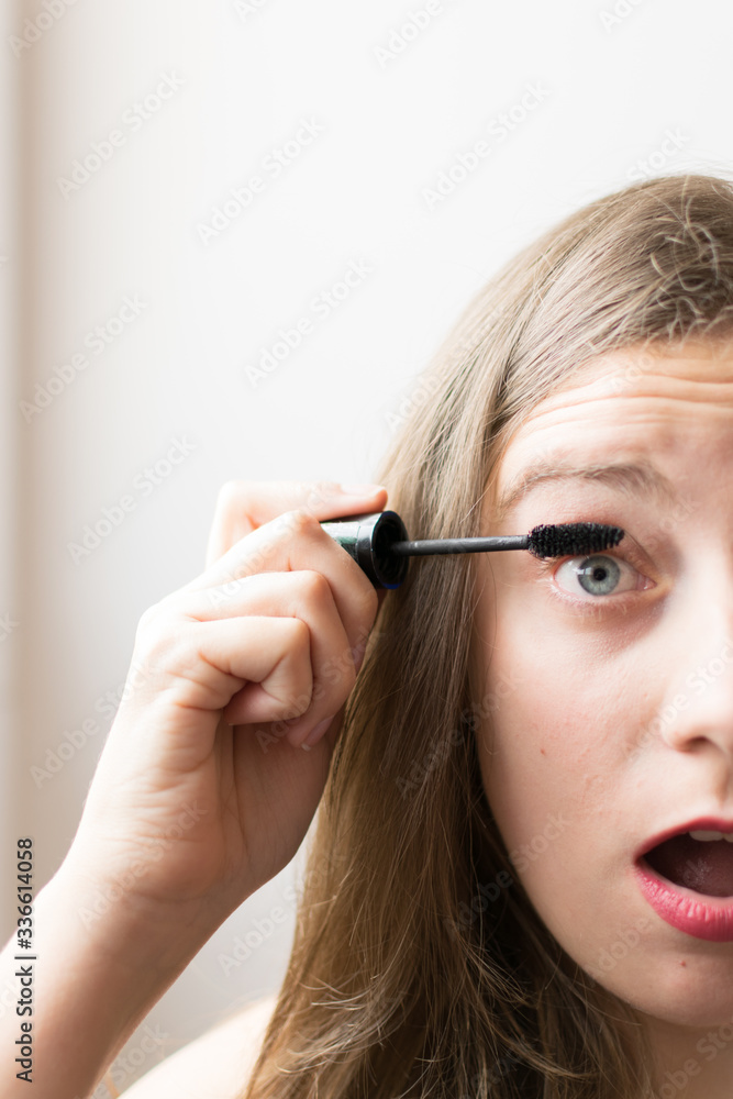 Young woman portrait putting on black mascara Young woman portrait putting on black mascara