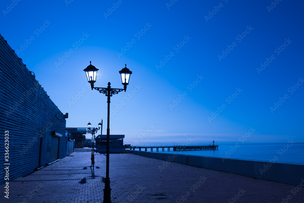 Deserted night sea promenade in the light of the moon. postcard.