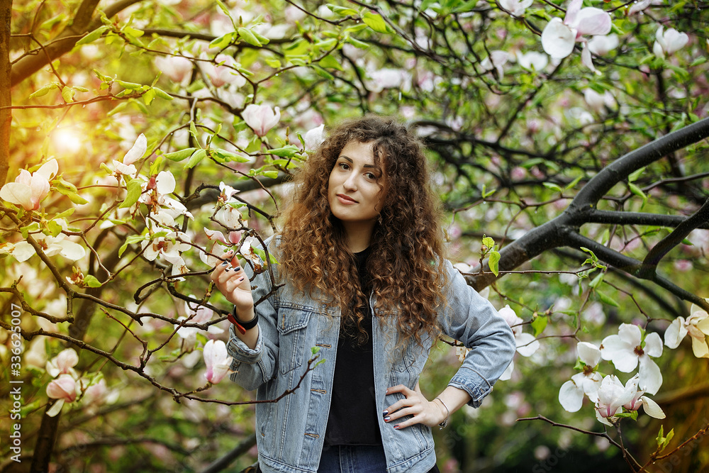 Curly girl in magnolias. Spring. Botanical Garden. Curly girl in magnolias. Spring. Botanical Garden.