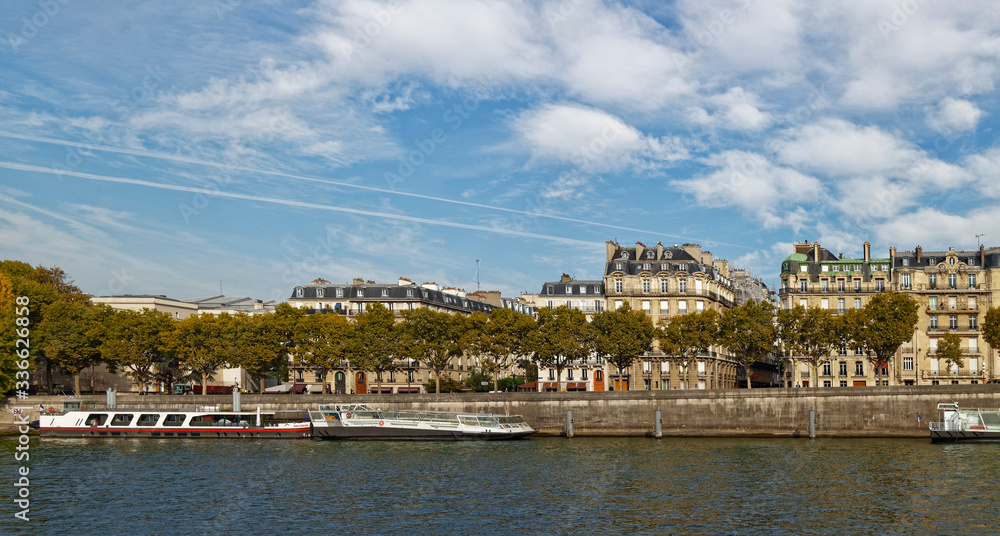 Moored River Barges next to the Stone built banks of the River Seine in Central Paris.
