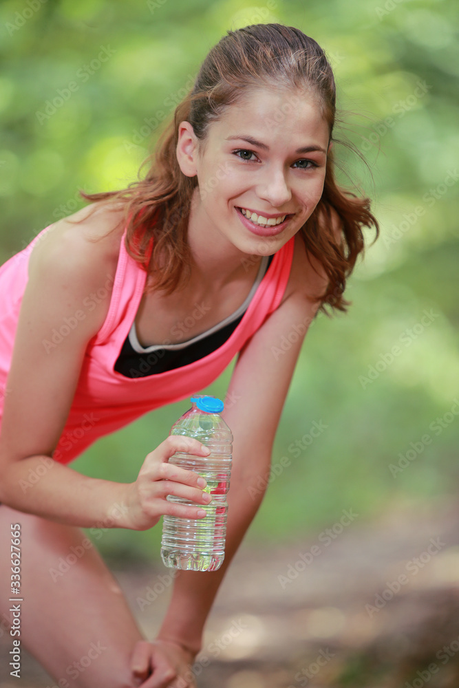 Jeune femme s'hydratant pendant son footing Jeune femme s'hydratant pendant son footing