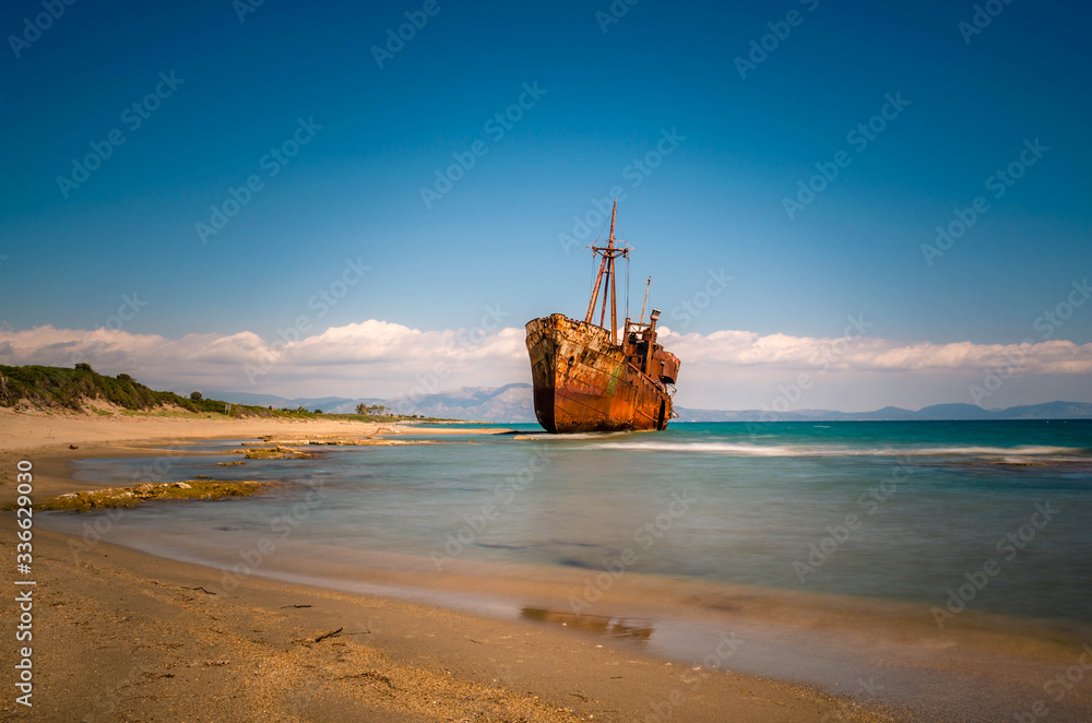 Rusty and abandoned shipwreck stands on a coastline near Gythio in Lakonia.
