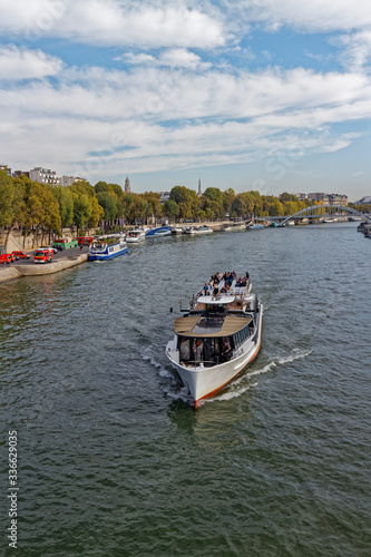 A traditional River Vessel carrying Tourists along a scenic River Cruise through Central Paris on the River Seine.