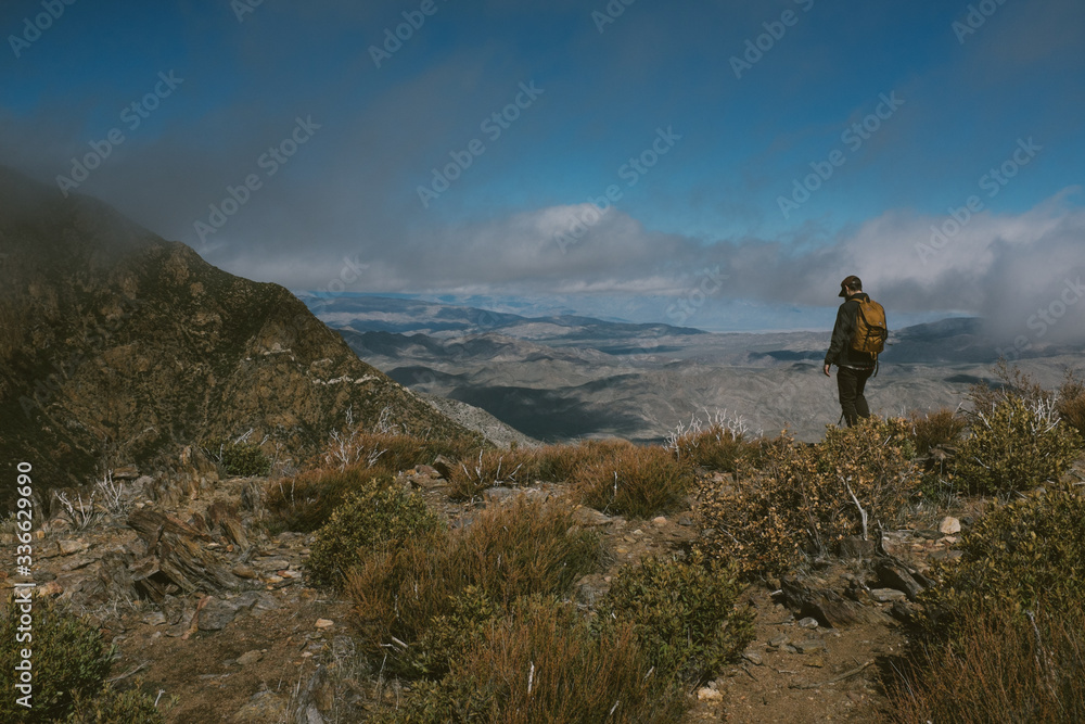 man overlooking mountains with blue sky