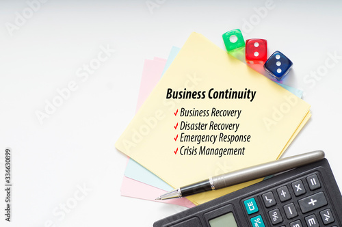 Business Continuity Plan. Calculator, pen, color paper and dices with copyspace