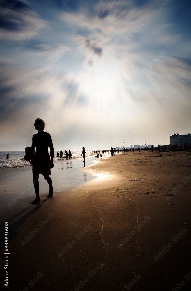Fototapeta premium silhouette of a man walking on the beach