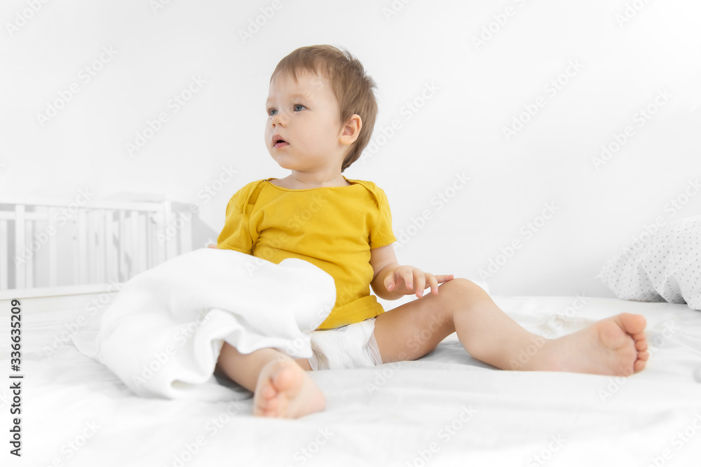 Portrait of male baby with toy on bed in her room