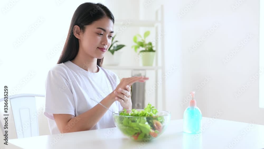 Asian woman using alcohol hand wash gel sanitizer to wash her hand for prevent coronavirus, covid-19, 201-nCoV and other germ disease before eating. Asian woman using alcohol hand wash gel sanitizer to wash her hand for prevent coronavirus, covid-19, 201-nCoV and other germ disease before eating.
